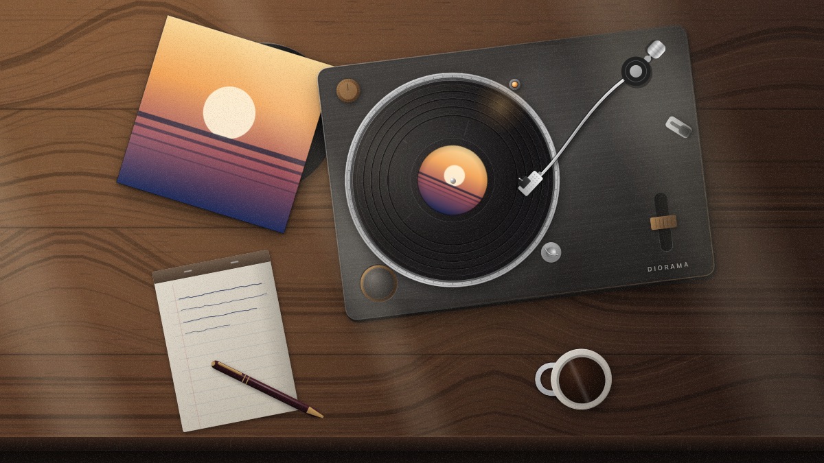 The same turntable seen from further back, lying askew on a walnut desk beside a ruled notepad with a fountain pen lying across it and a mug of black coffee.